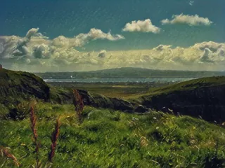 a grassy hill with a view of the land and a body of water 
ireland-100.webp Land of Ireland